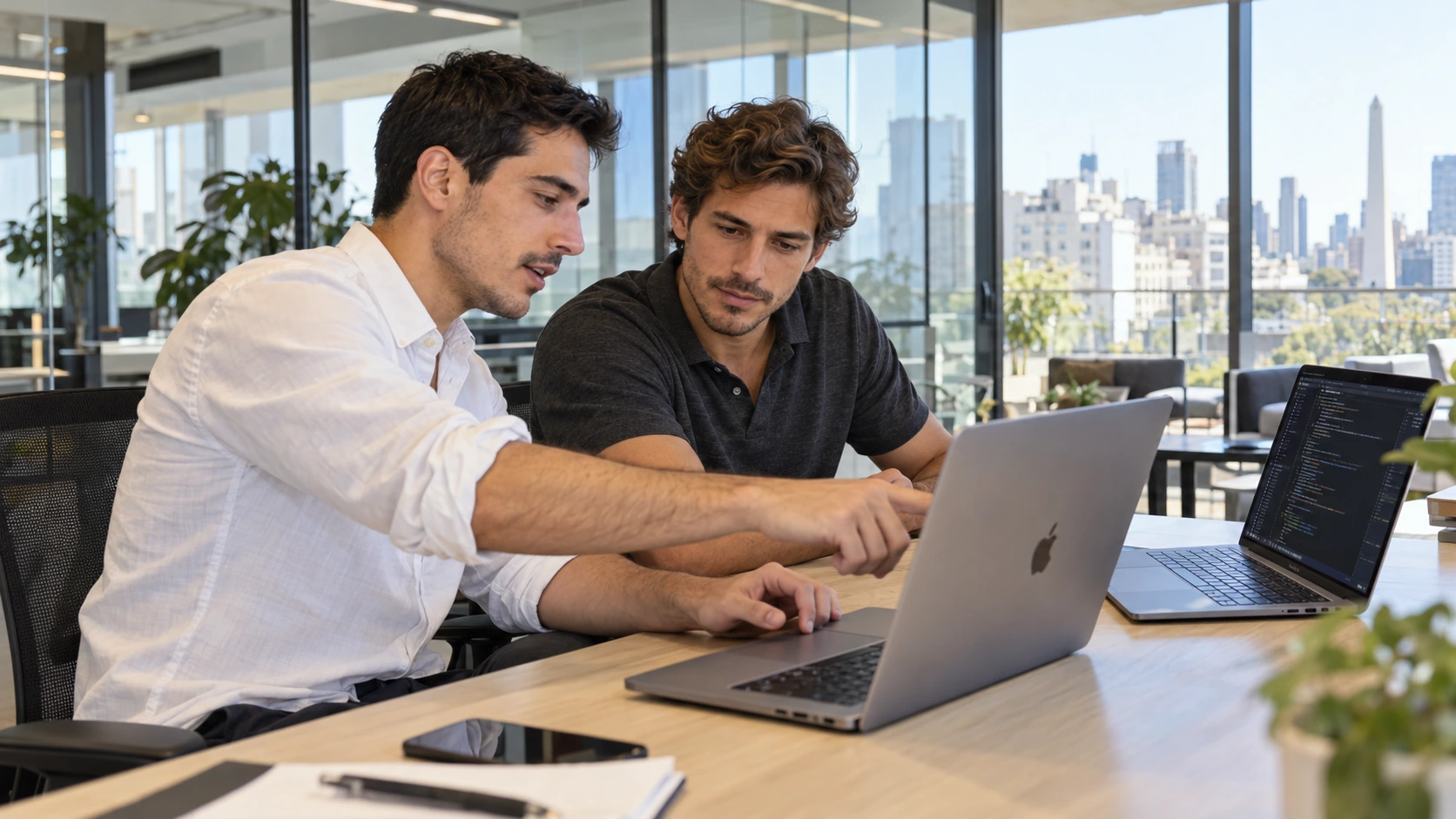 Two colleagues discussing work on a laptop.